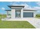 Inviting single-story home with a beautifully landscaped yard, gray roof, and stylish garage door at 234 Cougar Way, Rotonda West, FL 33947
