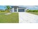 Attractive single-story home with a well-maintained lawn, gray roof, and a lovely palm tree accent at 234 Cougar Way, Rotonda West, FL 33947