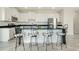 Modern kitchen with white cabinets, black countertops, stainless steel appliances, and bar stool seating at 234 Cougar Way, Rotonda West, FL 33947