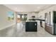 Bright kitchen with stainless steel appliances, a center island and grey tiled floors at 234 Cougar Way, Rotonda West, FL 33947