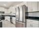 Well-equipped kitchen featuring stainless steel appliances, white cabinets, and sleek black countertops at 234 Cougar Way, Rotonda West, FL 33947
