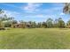 Expansive backyard featuring lush green grass, mature trees, and the house in the background at 2700 Sheboygan Ave, North Port, FL 34286