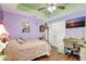 Cozy bedroom featuring light purple walls, ceiling fan, wood floors, and a convenient desk for work or study at 2700 Sheboygan Ave, North Port, FL 34286
