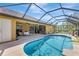 Screened-in pool area with outdoor seating and a built-in outdoor kitchen for entertainment at 2700 Sheboygan Ave, North Port, FL 34286