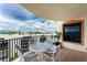 This outdoor balcony has ocean and city views with an outdoor table and chairs and a lush, green potted plant at 2792 N Beach Rd # 301, Englewood, FL 34223
