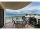 Outdoor balcony overlooking the ocean with a table and chairs providing the perfect spot to enjoy coastal views at 2792 N Beach Rd # 301, Englewood, FL 34223