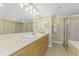 Bathroom with a long vanity, a large mirror, and a tiled shower at 2792 N Beach Rd # 301, Englewood, FL 34223