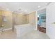 Bright bathroom featuring a large tub with shower and tiled floor at 2792 N Beach Rd # 301, Englewood, FL 34223