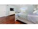 Bedroom with blue bedding, a light blue wall, and wood flooring at 2792 N Beach Rd # 301, Englewood, FL 34223