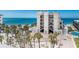 Attractive building near the beach, surrounded by mature palm trees and well-maintained landscaping at 2792 N Beach Rd # 301, Englewood, FL 34223