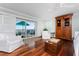Bright main bedroom featuring hardwood floors, balcony access, and a comfortable seating area at 2792 N Beach Rd # 301, Englewood, FL 34223