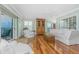 Bright main bedroom featuring hardwood floors, balcony access, and a comfortable seating area with stylish furnishings at 2792 N Beach Rd # 301, Englewood, FL 34223