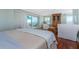 Bright main bedroom featuring hardwood floors, a sliding glass door to the balcony, and comfortable furnishings at 2792 N Beach Rd # 301, Englewood, FL 34223