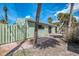 Landscaped backyard with brick pathway, lush palm trees, green siding, and rear entrance at 2980 N Beach Rd # Gv16, Englewood, FL 34223