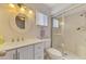 Bright bathroom with white vanity, double sinks, tile shower and updated fixtures at 2980 N Beach Rd # Gv16, Englewood, FL 34223