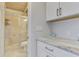 Bathroom features glass shower, white cabinets with marble counters and tile floors at 2980 N Beach Rd # Gv16, Englewood, FL 34223
