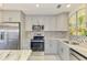 Modern kitchen with stainless steel appliances, sleek gray cabinets, and stylish backsplash at 2980 N Beach Rd # Gv16, Englewood, FL 34223