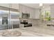 Bright kitchen features stainless appliances, light gray cabinets, granite counters and backsplash at 2980 N Beach Rd # Gv16, Englewood, FL 34223
