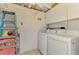 Laundry room with washer, dryer, cabinets, and shelving for storage and organization at 2980 N Beach Rd # Gv16, Englewood, FL 34223