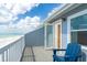 Outdoor deck with blue Adirondack chair overlooking the beach and Gulf waters at 301 S Gulf Blvd # 419, Placida, FL 33946