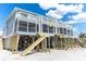 Elevated beach house exterior showcasing stairs leading to an outdoor deck at 301 S Gulf Blvd # 419, Placida, FL 33946