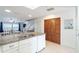 Bright kitchen with granite countertops, white cabinets, and open layout to dining area at 301 S Gulf Blvd # 419, Placida, FL 33946