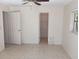 Neutral bedroom with a ceiling fan, tiled floor, and an open closet at 3278 Cabaret St, Port Charlotte, FL 33948