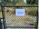 The image shows a chain link fence with a sign indicating property extends beyond fence at 3278 Cabaret St, Port Charlotte, FL 33948