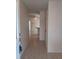 View down a tiled hallway to a dining area with a ceiling fan and breakfast bar at 3278 Cabaret St, Port Charlotte, FL 33948