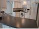 Efficient kitchen layout with white appliances, dark countertops, and a view to the living area at 3278 Cabaret St, Port Charlotte, FL 33948