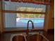 Kitchen sink with a view of the screened-in pool area and backyard greenery at 3278 Cabaret St, Port Charlotte, FL 33948