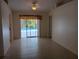 Open living room features neutral paint, ceramic tile flooring, and sliding door to outdoor pool at 3278 Cabaret St, Port Charlotte, FL 33948