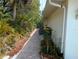 Side yard with brick pavers, landscaping, and utilities along the side of the house at 3278 Cabaret St, Port Charlotte, FL 33948