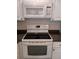 The image shows a stove with black cook top, under microwave, and gray countertops at 3278 Cabaret St, Port Charlotte, FL 33948