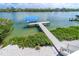 Picturesque waterfront view of a dock with a boat lift surrounded by lush greenery and serene waters at 342 S Gulf Blvd, Placida, FL 33946