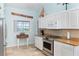 Close-up of kitchen with white cabinets, stainless steel appliances, granite counters, and a window view at 342 S Gulf Blvd, Placida, FL 33946