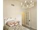 Cozy bedroom with chandelier, floral pillows, and glass paneled door at 351 Bobby Jones Rd # 351, Sarasota, FL 34232