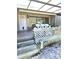 Covered patio with white seating, lush landscaping, and front door access at 351 Bobby Jones Rd # 351, Sarasota, FL 34232