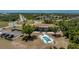 Expansive aerial view showcasing a swimming pool, mature trees, and an adjacent parking lot for convenient access at 3586 Cape Haze N Dr # B6, Rotonda West, FL 33947
