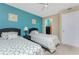 Bedroom features twin beds, blue accent wall, and an open closet for easy storage access at 3586 Cape Haze N Dr # B6, Rotonda West, FL 33947