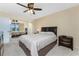 Neutral bedroom with a king bed, mirrored closet, and a ceiling fan at 3586 Cape Haze N Dr # B6, Rotonda West, FL 33947