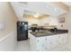 A compact kitchen with white cabinets, a black refrigerator, and dark countertops at 3586 Cape Haze N Dr # B6, Rotonda West, FL 33947