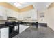 Efficient kitchen features black appliances, white cabinets, and a double sink at 3586 Cape Haze N Dr # B6, Rotonda West, FL 33947