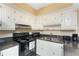 Well-organized kitchen with white cabinets, black appliances, and durable countertops at 3586 Cape Haze N Dr # B6, Rotonda West, FL 33947