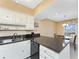 Kitchen with dark countertops, a double sink, and a view to an eat-in dining space at 3586 Cape Haze N Dr # B6, Rotonda West, FL 33947