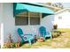 Close up on a single-story home with teal awning and chairs in front yard at 360 W Cowles St, Englewood, FL 34223
