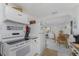 Kitchen featuring white appliances, white cabinets, and an open layout at 360 W Cowles St, Englewood, FL 34223