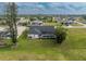 An aerial view of a house with a screened pool, surrounded by trees and a well-maintained lawn at 4 Bunker Rd, Rotonda West, FL 33947
