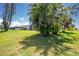 Lush backyard featuring mature palms and green lawn at 4 Bunker Rd, Rotonda West, FL 33947