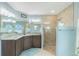 Bathroom featuring a dual-sink vanity, tiled shower, and ample lighting at 4 Bunker Rd, Rotonda West, FL 33947